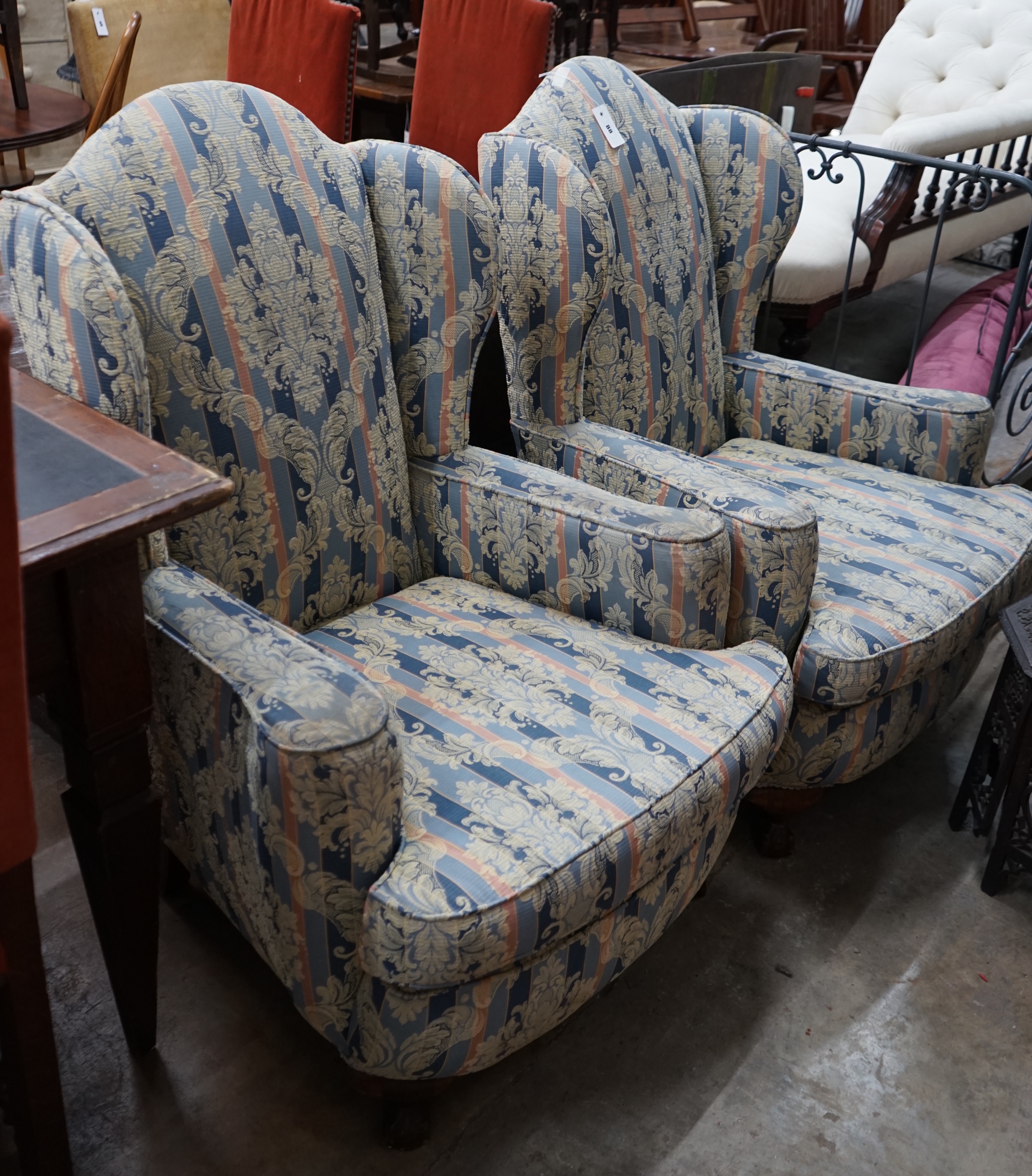 A pair of 1920's upholstered wing armchairs, width 74cm depth 70cm height 106cm